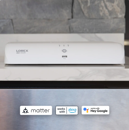White 4K NVR security recorder on a marble counter with Matter, Alexa, and Google Assistant compatibility icons below.
